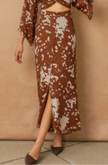 Brown floral dress with a slit skirt against a beige background