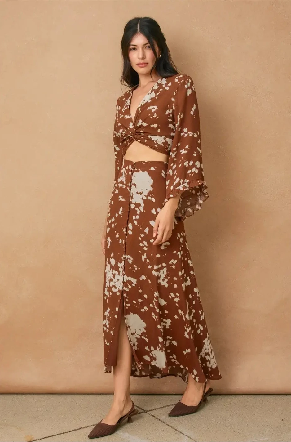 Woman wearing a brown floral outfit against a beige background